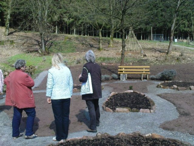 Gudrun Desch mit Teilnehmern einer Kräuterwanderung im Kräutergarten