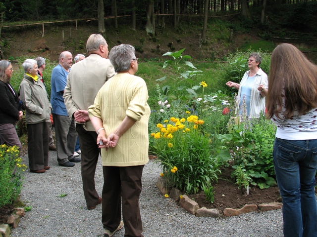 Gudrun Desch führt die Besucher durch den Kräutergarten